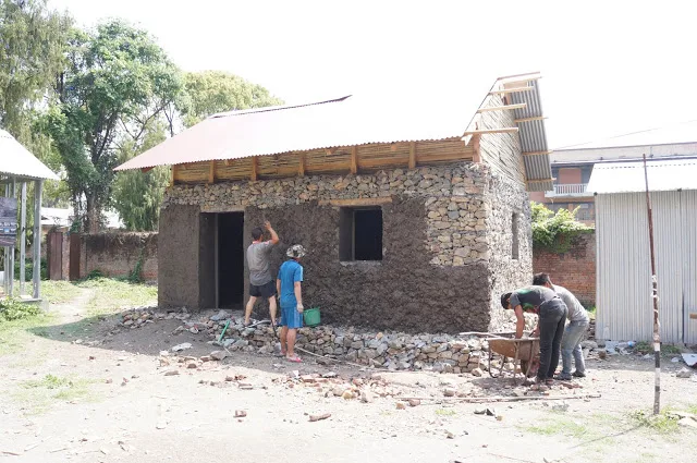 Une maison terminée : murs en gabions, ossature et toiture.