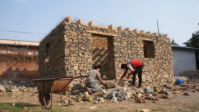Maison en micro-gabion : murs de pierres dans des cages en grillage d'acier