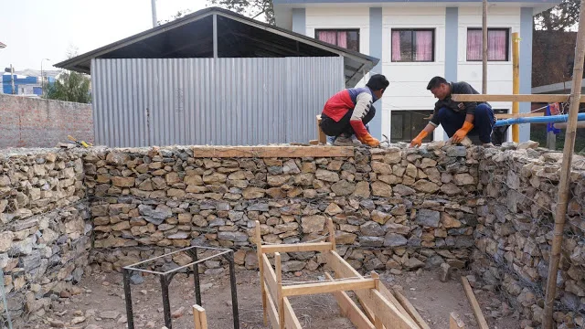 Les murs en gabions montent, rangée par rangée.