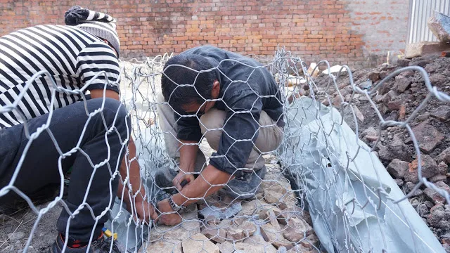 Assemblage des cages en grillage et remplissage de pierres.